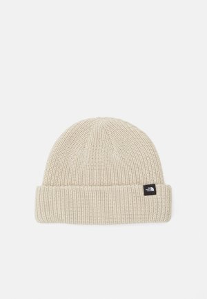 Beige strikket hue med foldet kant og lille sort logopatch på siden.