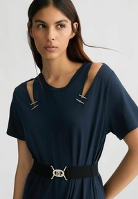 Abito navy a maniche corte con spalle scoperte, dettagli in oro e una cintura nera con una fibbia metallica con logo. Tessuto dalla texture liscia.