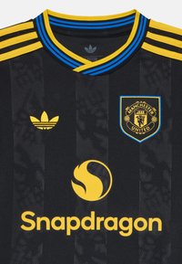 Must mustärk jersey, millel on kollased ja sinised triibud krae ümber ning kolm kollast triipu õlgadel. Kätkeb endas Manchester Unitedi logo ja Snapdragon brändingu.