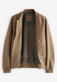 Veste bomber en daim marron avec poignets et col côtelés, partiellement dézippée pour montrer la doublure intérieure sombre et l'étiquette cousue au niveau du col.