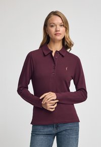 Burgundy långärmad polo tröja med krage, femknapps knäppning och liten broderad logga. Mjuk tyg med en slät textur.