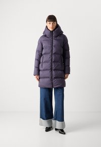 Paarse opblaasjas met een hoge kraag en capuchon, voorzien van horizontale stiksels, ritszakken en zwarte hardware-details.