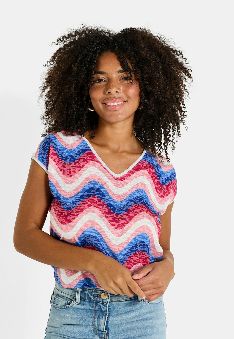Top de manga corta con cuello en V que presenta un patrón ondulado en rojo, rosa y azul, con un acabado texturizado y detalles en blanco contrastantes.