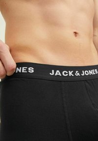 Boxer-briefs noirs avec une taille noire portant le texte blanc "JACK & JONES", en coton, au design ajusté avec une texture lisse.