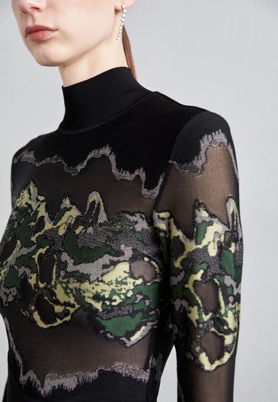 Long-sleeve top in black textured fabric with sheer sections and abstract green, gray, and yellow pattern; features a high ribbed neckline.