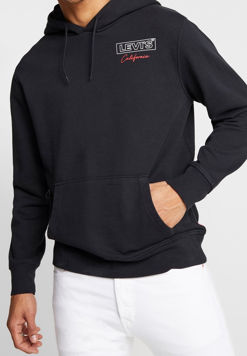 Sudadera de algodón negro con bolsillo delantero, capucha con cordón y logo bordado "LEVI'S California" en blanco y rojo en el pecho.