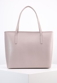 Jasnoróżowa torba typu tote wykonana z teksturowanego materiału, z dwoma długimi uchwytami i pojemnym, strukturalnym kształtem. Gładkie wykończenie z delikatnym połyskiem.