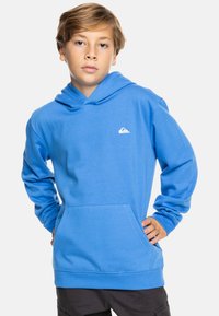 Sudadera con capucha azul, mezcla de algodón, bolsillo tipo canguro, puños y dobladillo acanalados, logo blanco en el pecho, ajuste relajado.
