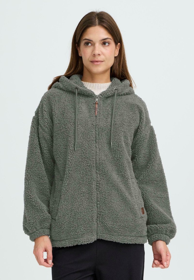 Grüne Fleece-Zip-up-Hoodie mit weicher Textur, einer Kordelzugkapuze und einem dezenten Logo am Saum. Verfügt über weite Ärmel und Fronttaschen.