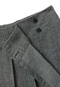 Tela de espina de pescado gris con un acabado texturizado, que presenta dos botones negros y un detalle de diseño plisado en la cintura.