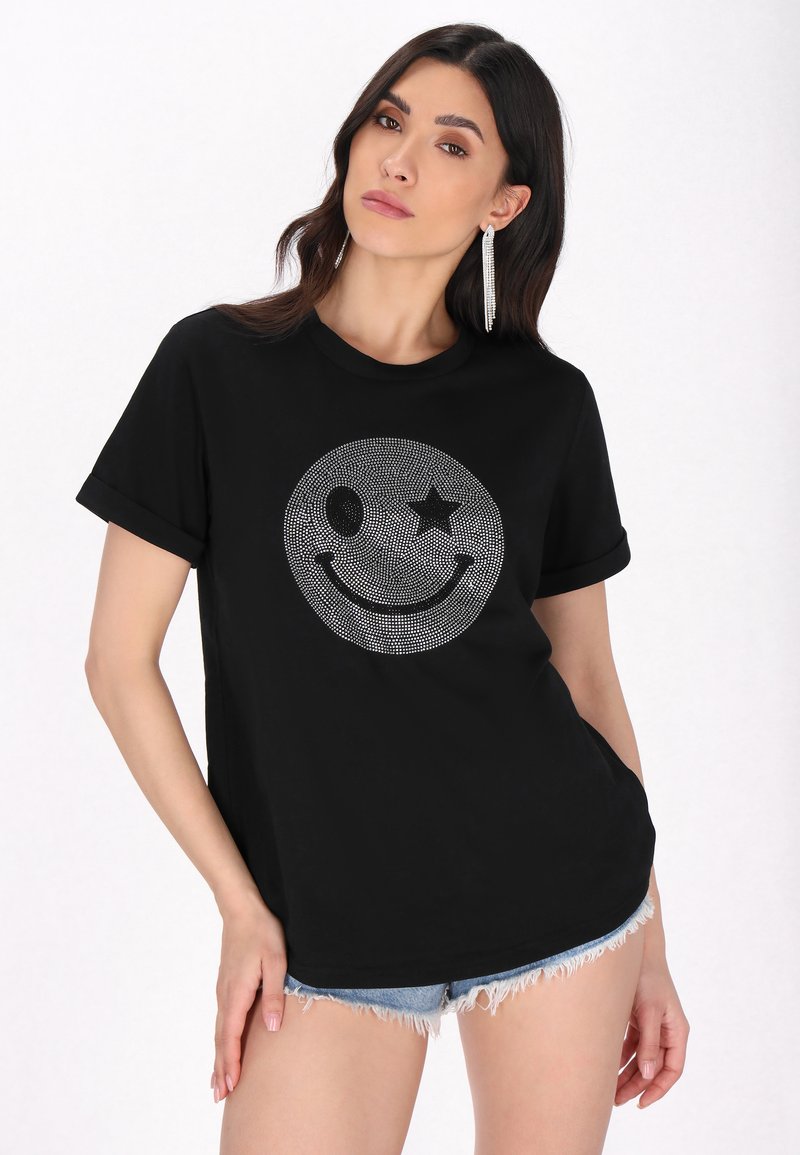 Tricou negru din bumbac, cu un design strălucitor al unei fețe zâmbitoare, însoțit de o stea și un ochi, cu mâneci scurte răsucite și croi lejer.