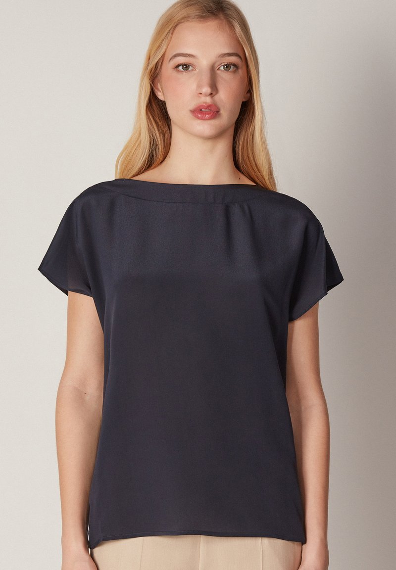 Mörkblå kortärmad topp med en bred båthals, tillverkad av mjukt tyg, med en avslappnad passform och subtil drapering.