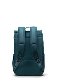 Mörk teal ryggsäck med vadderade axelremmar, slät yta, handtag upptill och framficka. Enkel, rektangulär design med minimal detaljering.