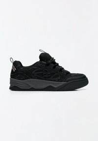 Baskets de sport noires en tissu texturé, semelle épaisse, languettes à boucle sur la languette et le talon, avec des détails abstraits sur les côtés.