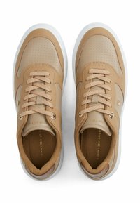 Beige lædersneakers med en glat tåboks, perforerede detaljer og en hvid gummisål. Inkluderer rund snørebånd og en guld logo detalje.