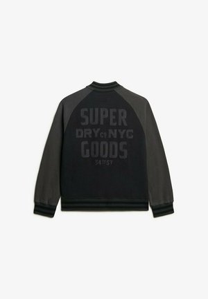 Sort og grå bomberjakke med ribbet krave og manchetter. Har fed tekst "SUPER DRY NYC GOODS 34TH ST" på tværs af ryggen.