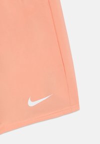 Pantalones cortos deportivos de Nike en suave tela melocotón, con un logo blanco en el dobladillo. Textura suave con un detalle de costura mínimo.