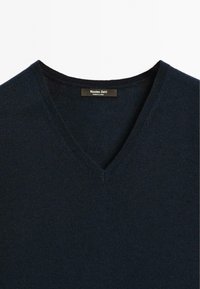 Dark navy V-neck sweater made from textured fabric, featuring a rib-knit neckline and a tag displaying "Massimo Dutti" inside.