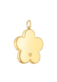 Ciondolo a forma di fiore in oro con una finitura lucida, inciso con "TOUS S925" su un lato, e un anello per il fissaggio.
