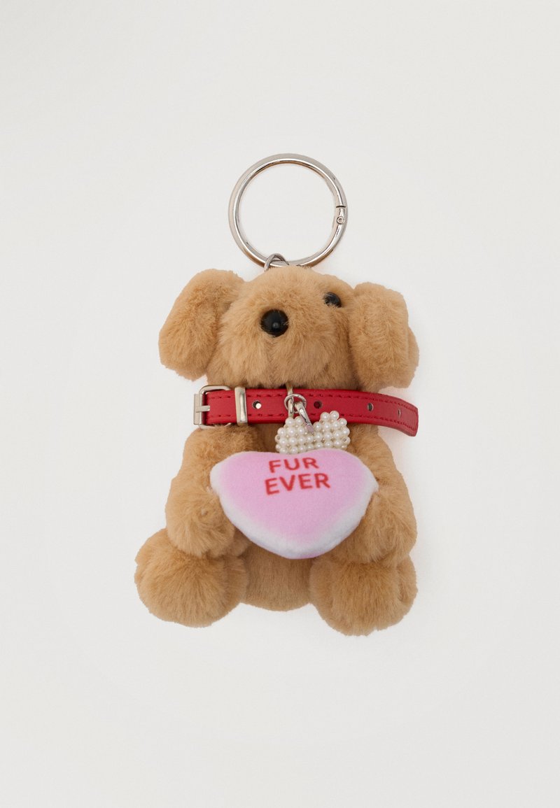 Porte-clés en peluche représentant un chien marron portant un collier rouge, tenant un cœur rose avec le texte « FUR EVER » et un petit charm en forme de nœud orné de perles.