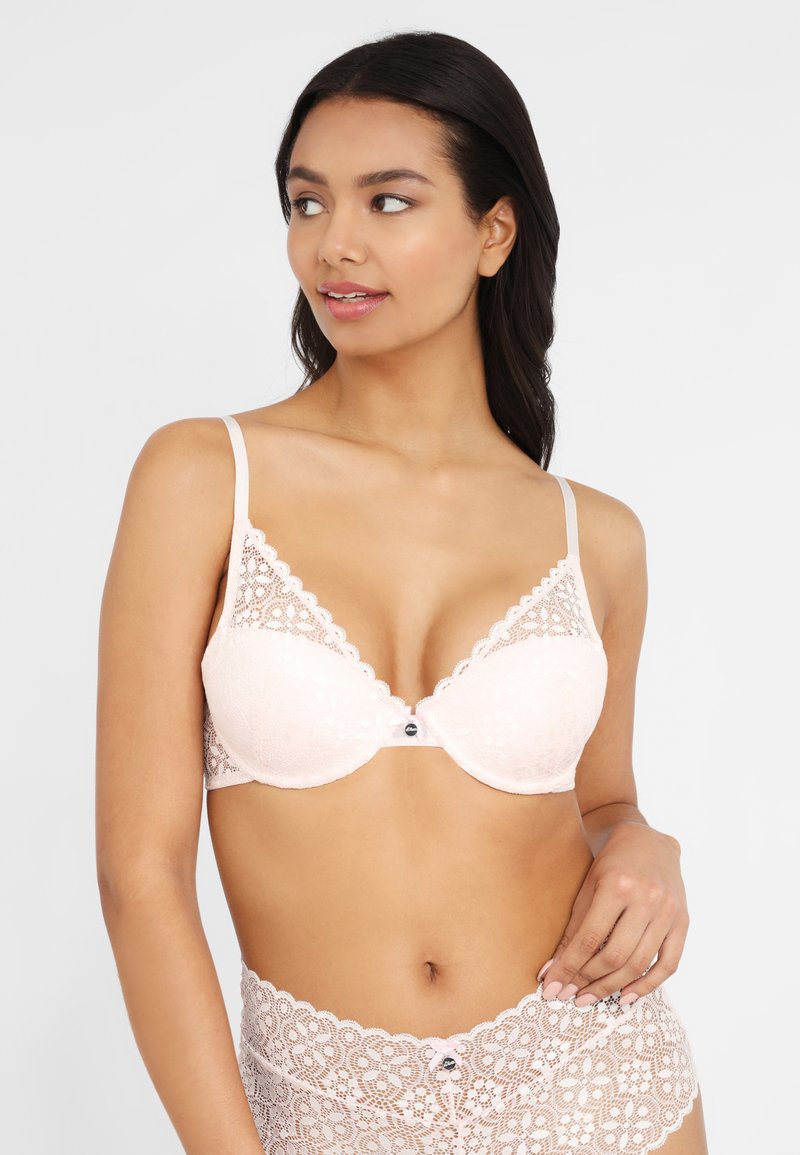 Spitzen-Bralette in zartem Rosa mit gewellten Kanten und Unterstü tzung durch Bügel. Verfügt über verstellbare Träger und ein dekoratives Knopfdetail an der Vorderseite.