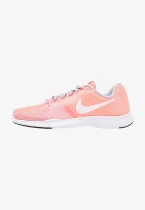 Baskets de sport rose clair avec un dessus en maille, swoosh blanc de Nike, accents gris et semelle blanche. Présente une surface texturée et un design épuré.