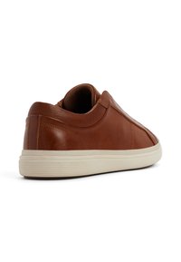 Braune Leder-Sneaker mit abgerundetem Absatz, strukturiertem Design auf der Rückseite und einer cremefarbenen Gummisohle. Verfügt über minimale Nähte und ein schlankes Profil.