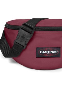 Mörkröd Eastpak midjeväska med en texturerad tyg, svart justerbar rem och plastspänne. Har en logotyppatch på framsidan.