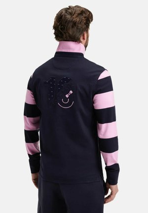 Pull marine avec des manches rayées rose et noir, présentant un grand détail "10" au dos en tissu texturé. Coupe décontractée et col.