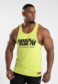 Geltonas tank top'as su juodu "GORILLA WEAR" logotipu ir "JAV" tekstu; medvilnės medžiaga; laisvas pjūvis; be rankovių dizainas.