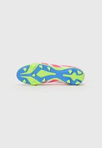 Voetbalschoen met een multicolore rubberen zool met blauwe, groene en gele accenten; bovenkant heeft roze en witte strepen voor zichtbaarheid.