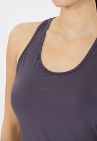 Lila sportlicher Tank-Top mit rundem Ausschnitt, hergestellt aus glattem Stoff. Mit dezentem "ENDURANCE" Branding in passendem Farbton.