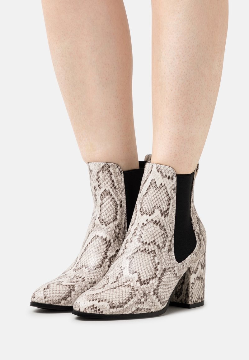 Bottes cheville en cuir Python avec talon bloc, dotées de panneaux latéraux noirs, texture lisse et design à bout pointu.