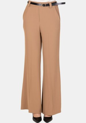 Pantaloni a gamba larga color camoscio con pieghe frontali, tasche laterali, cintura nera e tacchi neri a punta indossati da una persona.