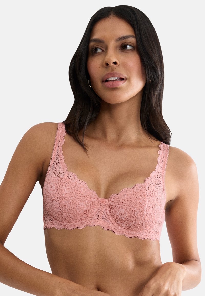Ροζ δαντελένιο σουτιέν bralette με κυματιστά άκρα και λουλουδένια σχέδια, με ρυθμιζόμενους ιμάντες και λείο, απαλό υλικό.