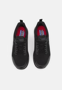 Schwarze Sneaker aus Mesh-Gewebe mit verstärkter Zehenkappe und rutschfester Sohle. Mit schwarzen Schnürsenkeln und roten Memory-Schaum-Einlegesohlen mit Markenlogo.