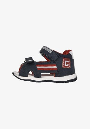 Sandali in tessuto blu navy e rossi con cinturini in velcro, design open-toe e suola in gomma bianca con pattern di trazione neri.