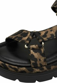 Løveprikkede sandaler med svart lærsåle, stoffremmer, gullfarget hardware og en tykk svart såle. Har en teksturert overflate.