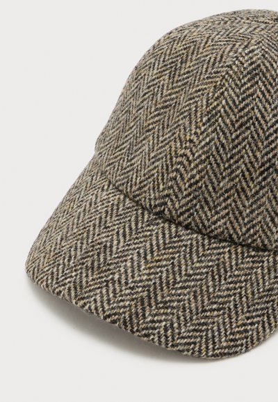 Casquette de baseball avec un motif en tweed chevron marron et beige, montrant une visière incurvée et un détail de couronne arrondie.