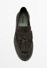 Mocassini in pelle scamosciata grigio scuro con suola piatta, caratterizzati da un design con cuciture e due nappine sul davanti. Fodera interna liscia.