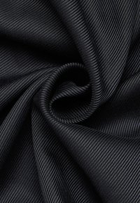 Tessuto nero a coste con superficie liscia e testurizzata, caratterizzato da strisce diagonali e un leggero lucido, piegato per mostrare la sua caduta e profondità.
