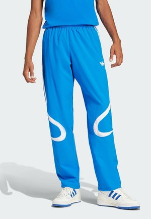 Blue athletic pants made of lightweight material with white curved accents and side stripes, featuring an elastic waistband, paired with white sneakers.