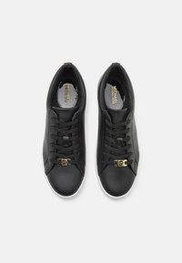 Schwarze Leder Sneaker mit einer Schnürendesign, Logo-Akzent in der Nähe der Schnürsenkel, weiße Gummisohle und glatter Textur. Das Innere weist ein Branding-Detail auf.