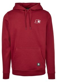 Sweat à capuche marron avec poche avant, cordons de serrage, petit logo étoile blanc sur la poitrine et étiquette près de la poche.