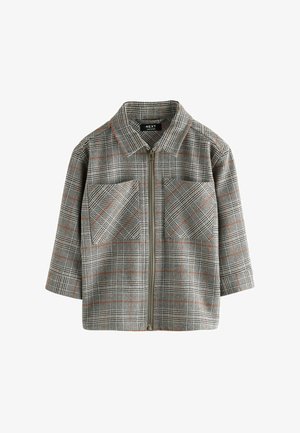 Szürke kockás kabát, cipzárral elöl, két mellzsebbel, narancssárga díszítéssel a mintázaton, és strukturált gallérral. Texturált anyagból készült.