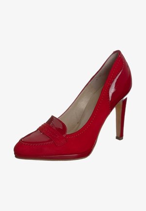 Escarpin à talon haut en cuir verni rouge avec bout pointu, bride décorative et doublure intérieure beige.