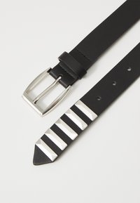Ceinture en cuir noir avec une boucle rectangulaire en argent et cinq clous en métal géométriques le long de la sangle, présentant une texture lisse.