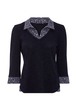 Marineblauw langemouwen blouse met een V-hals, voorzien van een contrasterende bloemenprint op de kraag en manchetten. Getextureerde stof met een ontspannen pasvorm.