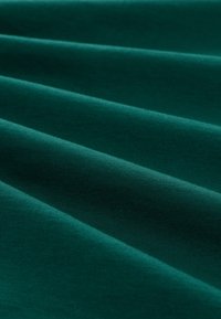 Turkizna tkanina z gladko teksturo in subtilnim sijajem, ki ima nežne gube, ki ustvarjajo mehko, valovito izgled. Brez vidnih vzorcev ali dodatkov.