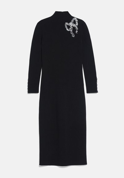 Robe midi noire à manches longues avec col haut et nœud décoratif en strass sur l'épaule gauche.